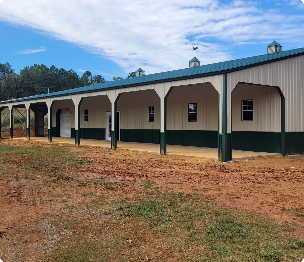 Large metal barn with green accents.